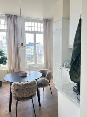 a kitchen with a table and two chairs with a candle at Maison Violette Antwerp in Antwerp