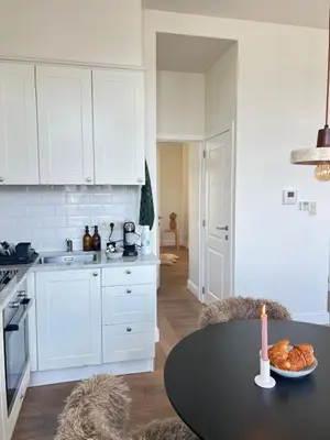 a kitchen with a table with a candle on it at Maison Violette Antwerp in Antwerp