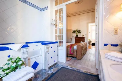 a bathroom with a tub and a sink and a bed at Master Suite Le Monarque Antwerp in Antwerp