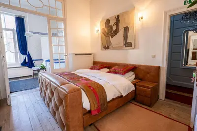 a large bed in a room with a large window at Master Suite Le Monarque Antwerp in Antwerp