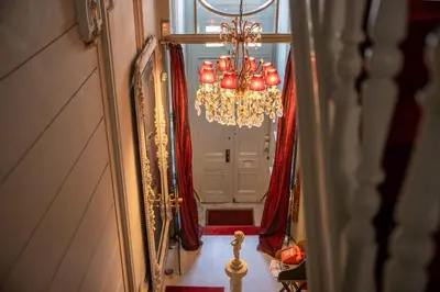 a chandelier in front of a door with red curtains at Master Suite Le Monarque Antwerp in Antwerp