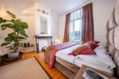 a bedroom with a bed and a potted plant at Le Machaon Antwerp Suite in Antwerp