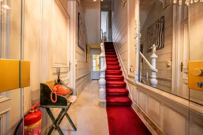 a hallway with red carpeting and stairs in a building at Le Machaon Antwerp Suite in Antwerp