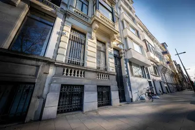 a building with a person on a bike in front of it at Le Machaon Antwerp Suite in Antwerp
