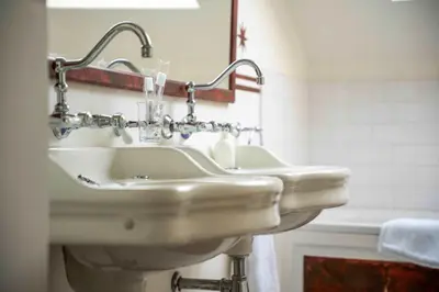 a white bathroom with two sinks and a mirror at Le Nymphale Suite Antwerp in Antwerp