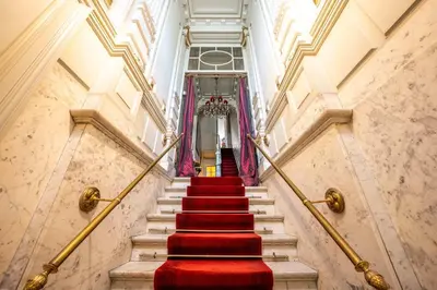 a staircase with red carpeted stairs in a building at Le Nymphale Suite Antwerp in Antwerp