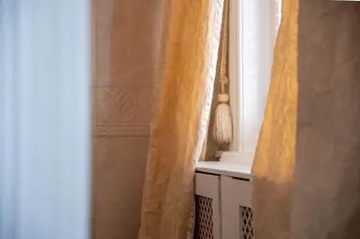 a bathroom with an orange curtain and a window at Le Nymphale Suite Antwerp in Antwerp