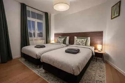 a bedroom with two beds and a window at Luma Residence in Brussels