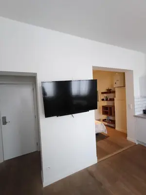 a flat screen tv on top of a white wall at Duplex apartment in the center, best comfort in Brussels