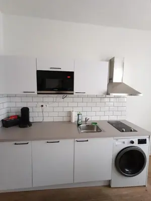 a white kitchen with a sink and a microwave at Duplex apartment in the center, best comfort in Brussels