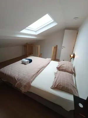 a bedroom with a large bed with a skylight at Duplex apartment in the center, best comfort in Brussels