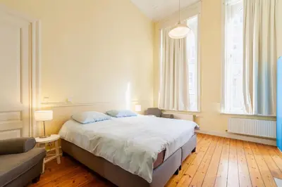 a bedroom with a large bed and a couch at Prime Location Apartment Chtelain Saint-Gilles Self checkin in Brussels