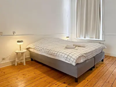 a bedroom with a bed and a table and a window at Prime Location Apartment Chtelain Saint-Gilles Self checkin in Brussels