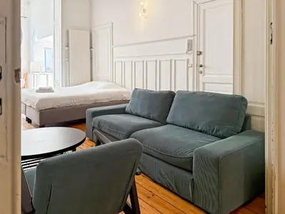 a living room with a couch and a bed at Prime Location Apartment Chtelain Saint-Gilles Self checkin in Brussels