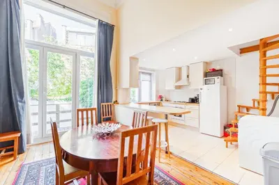 a kitchen and dining room with a table and chairs at Prime Location Apartment Chtelain Saint-Gilles Self checkin in Brussels