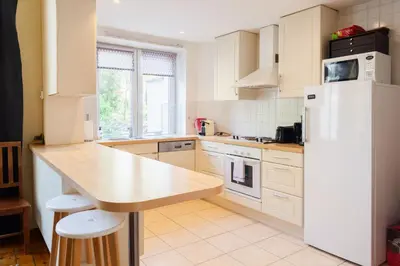 a kitchen with a white refrigerator and a counter at Prime Location Apartment Chtelain Saint-Gilles Self checkin in Brussels