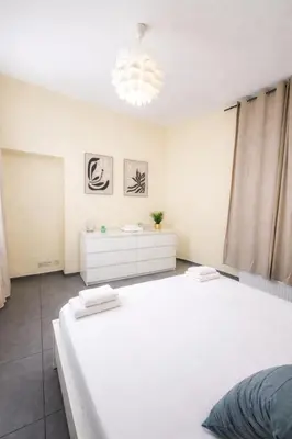 a bedroom with two white beds and a chandelier at Central Brussels Spacious 2BR near Grand Place 1 in Brussels
