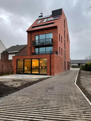 a red brick building with a balcony on a street at Apartment in Lochristi, close to Ghent & Lokeren! in Lochristi