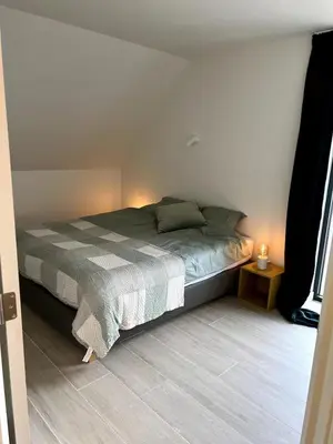 a bedroom with a bed in a room with a window at Apartment in Lochristi, close to Ghent & Lokeren! in Lochristi