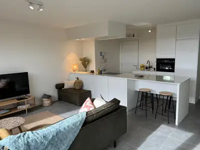 a living room with a couch and a kitchen at Apartment in Lochristi, close to Ghent & Lokeren! in Lochristi
