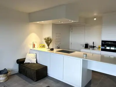 a kitchen with a white counter and a black stool at Apartment in Lochristi, close to Ghent & Lokeren! in Lochristi