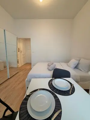 a room with two beds and a table with plates on it at Le sily appartement Bruxelles centre-ville in Brussels