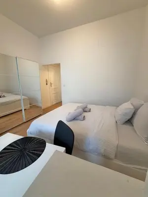 a bedroom with two beds and a table and a mirror at Le sily appartement Bruxelles centre-ville in Brussels