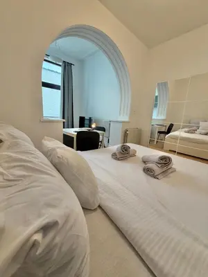a large white bed with two towels on top of it at Le sily appartement Bruxelles centre-ville in Brussels