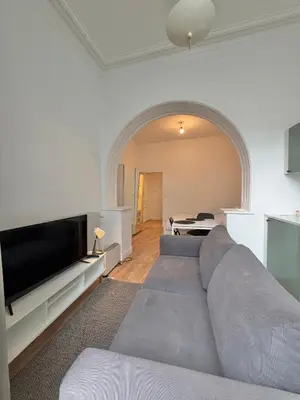 a living room with a couch and a tv at Le sily appartement Bruxelles centre-ville in Brussels