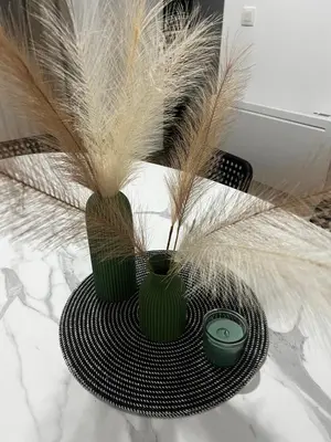 two green vases sitting on a table with feathers at Un cocon chaleureux in Brussels