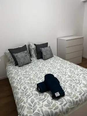 a bed in a bedroom with a blue pillow on it at Un cocon chaleureux in Brussels