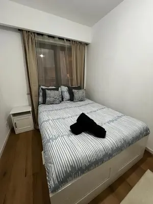 a bedroom with a bed with a black shirt on it at Un cocon chaleureux in Brussels