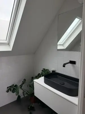 a bathroom with a black sink and a window at Amazing apartment with view in the centre in Antwerp