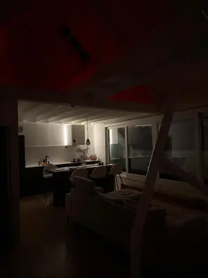 a dark living room with a couch and a kitchen at Amazing apartment with view in the centre in Antwerp