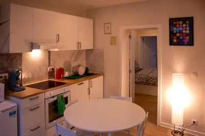 a kitchen with a white table and a table at Zoe's world in Brussels