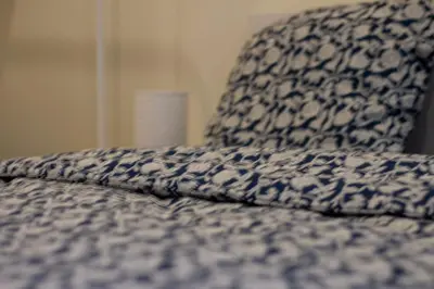 a blue and white comforter on top of a bed at Zoe's world in Brussels