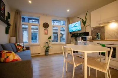 a kitchen and living room with a table and chairs at Zoe's world in Brussels