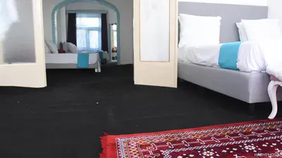 a bedroom with a bed and a mirror and a rug at Hébergement touristique à Bruxelles capitale 2026 in Brussels