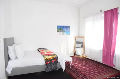 a bedroom with a white bed and a red rug at Hébergement touristique à Bruxelles capitale 2026 in Brussels