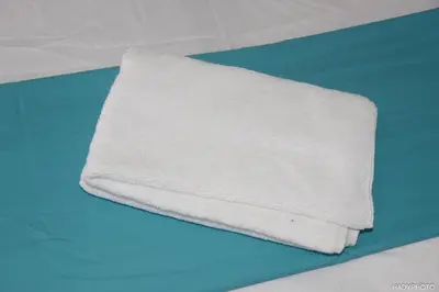 a white towel sitting on top of a bed at Hébergement touristique à Bruxelles capitale 2026 in Brussels