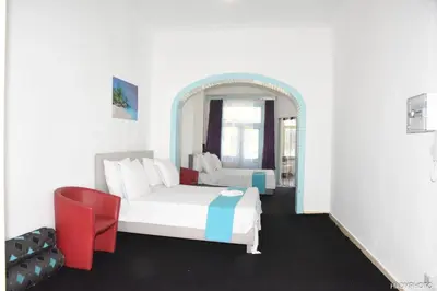 a bedroom with a white bed and a red chair at Hébergement touristique à Bruxelles capitale 2026 in Brussels