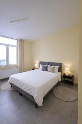 a large white bed in a bedroom with two lamps at Central Brussels Spacious 2BR near Grand Place3 in Brussels