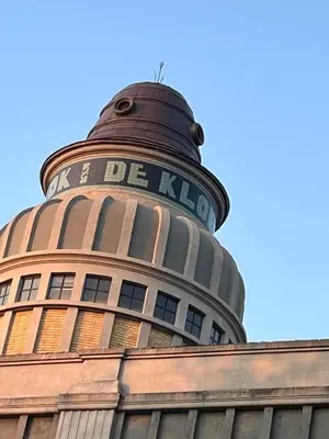 a building with a round tower with the words be klopp on it at Aplusstudio in Zottegem