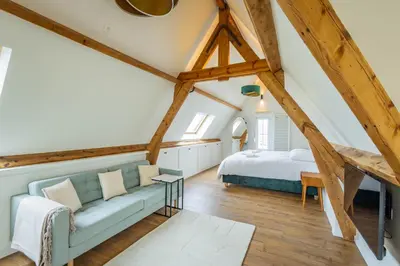 a room with a couch and a bed in a attic at Bed & Port luxury villa in Kallo