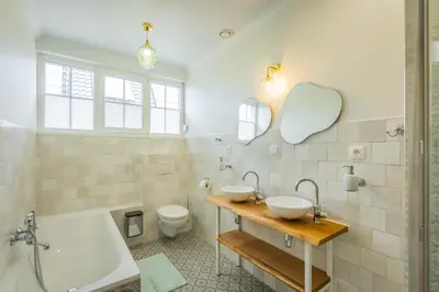 a bathroom with two sinks and a tub and a toilet at Bed & Port luxury villa in Kallo