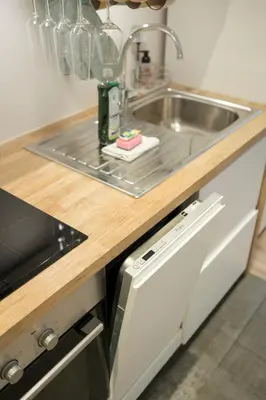 a kitchen counter with a sink and a dishwasher at Cosy 1 bedroom apartment close to Grand Place in Brussels