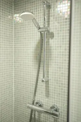 a shower in a bathroom with tiled walls at Cosy 1 bedroom apartment close to Grand Place in Brussels