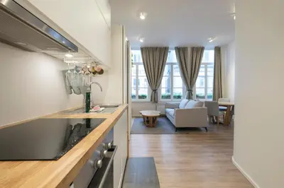 a kitchen and living room with a couch and a table at Cosy 1 bedroom apartment close to Grand Place in Brussels