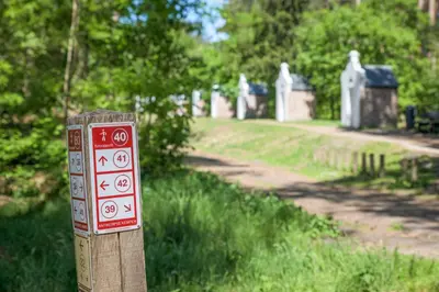 a sign on a wooden post in a cemetery at B&B Molmento in Mol