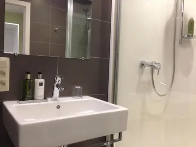 a bathroom with a white sink and a shower at RectoVersoVV in Sint-Pieters-Leeuw